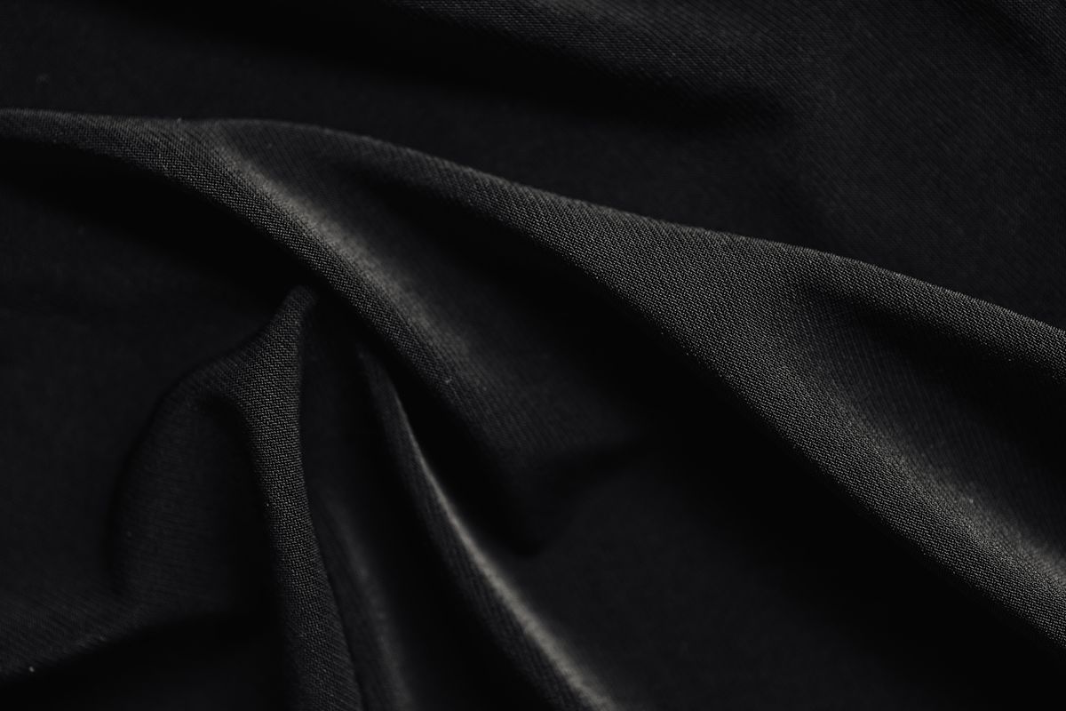 Smooth black polyester jersey in soft folds