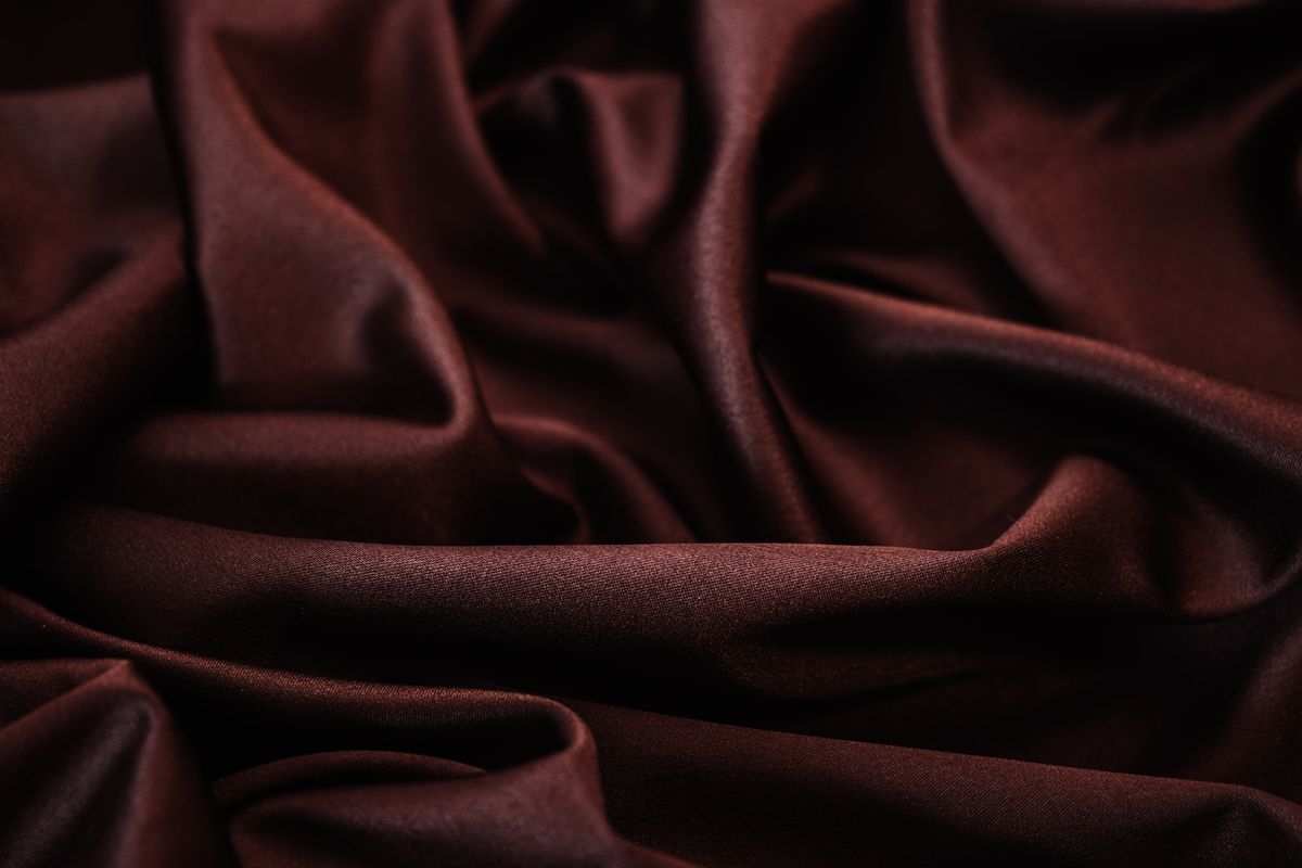 Deep maroon viscose falling in fluid, glossy drape